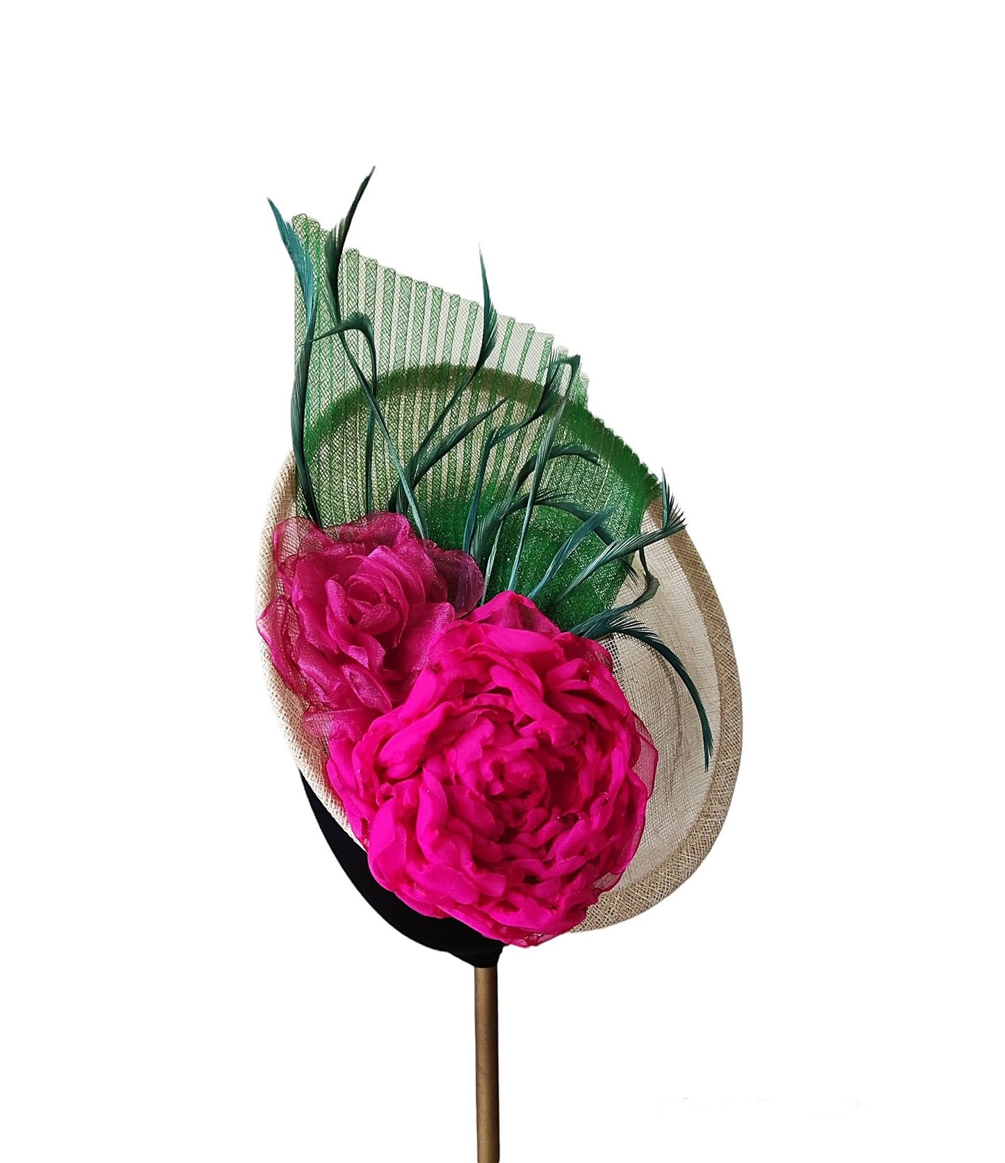 Vista de medio perfil del tocado lateral en sinamay natural con flores fucsia, crinolina y plumas