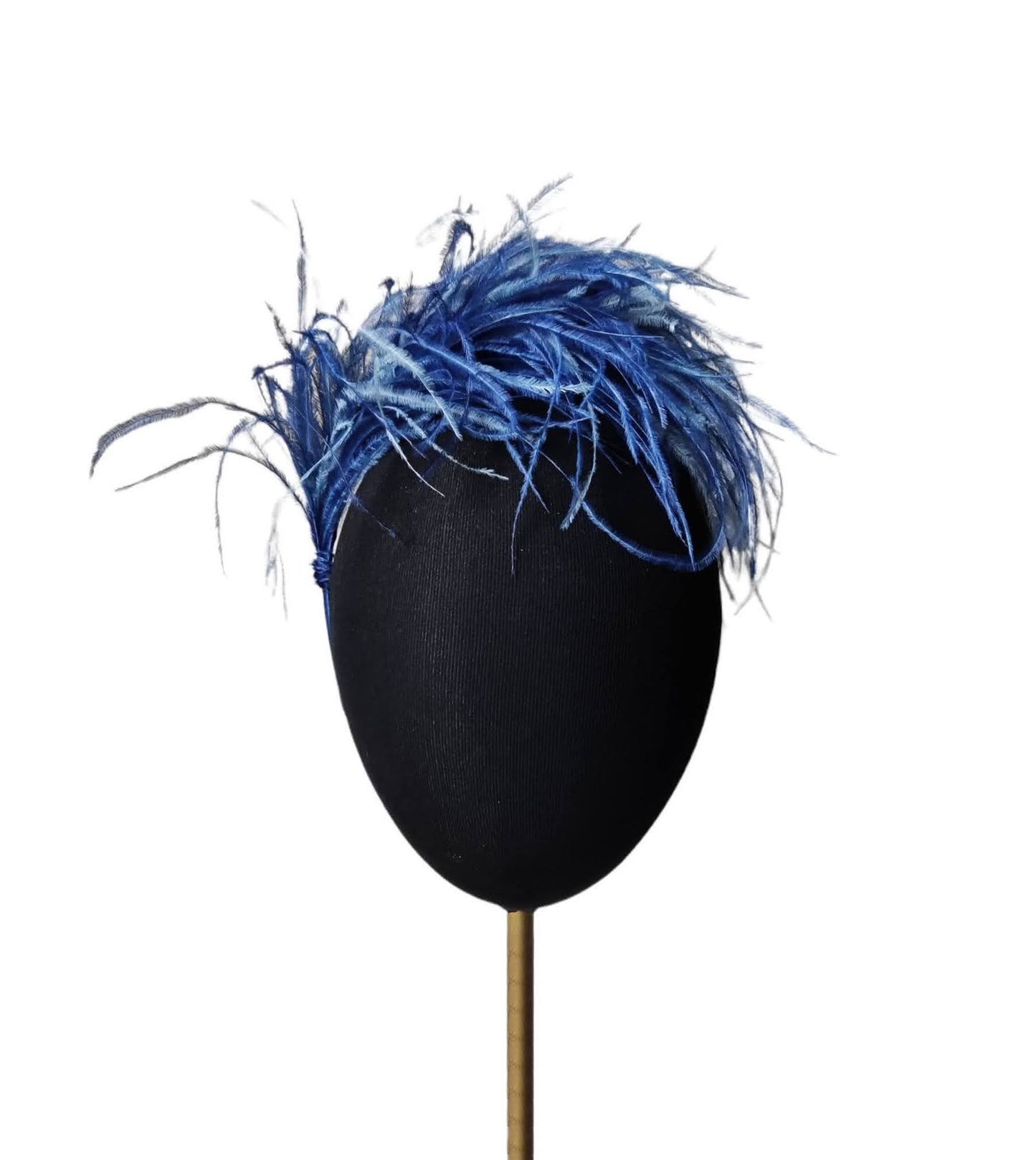 Tocado de fiesta con plumas de avestruz en azul marino y azul royal sobre cabeza de maniquí.