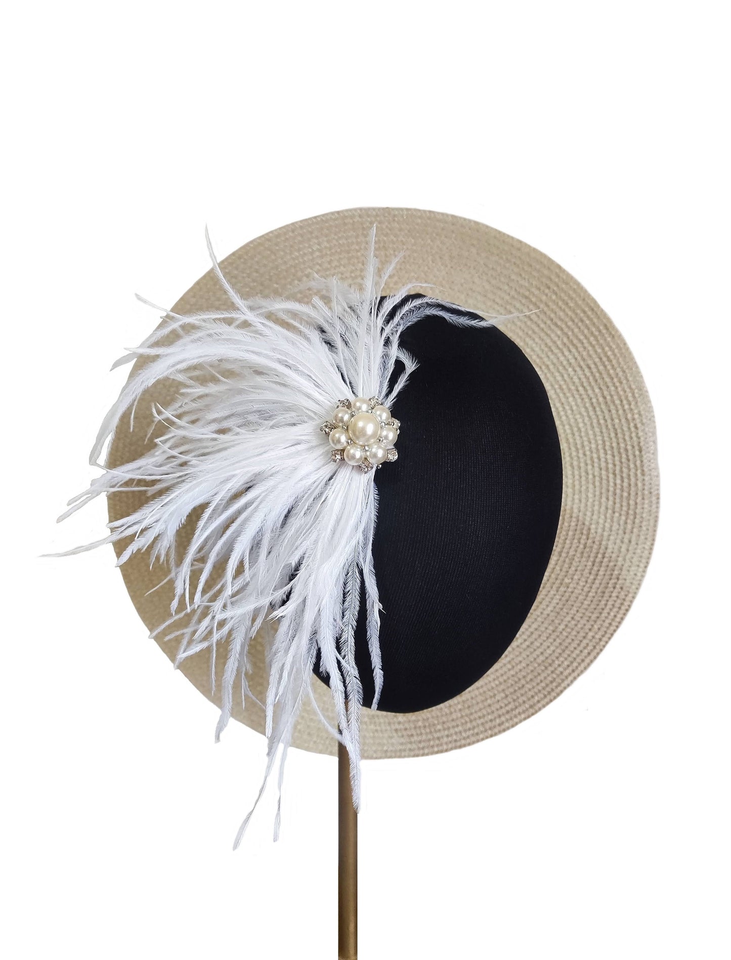 Tocado de plumas blancas con perlas y cristal sobre maniquí.
