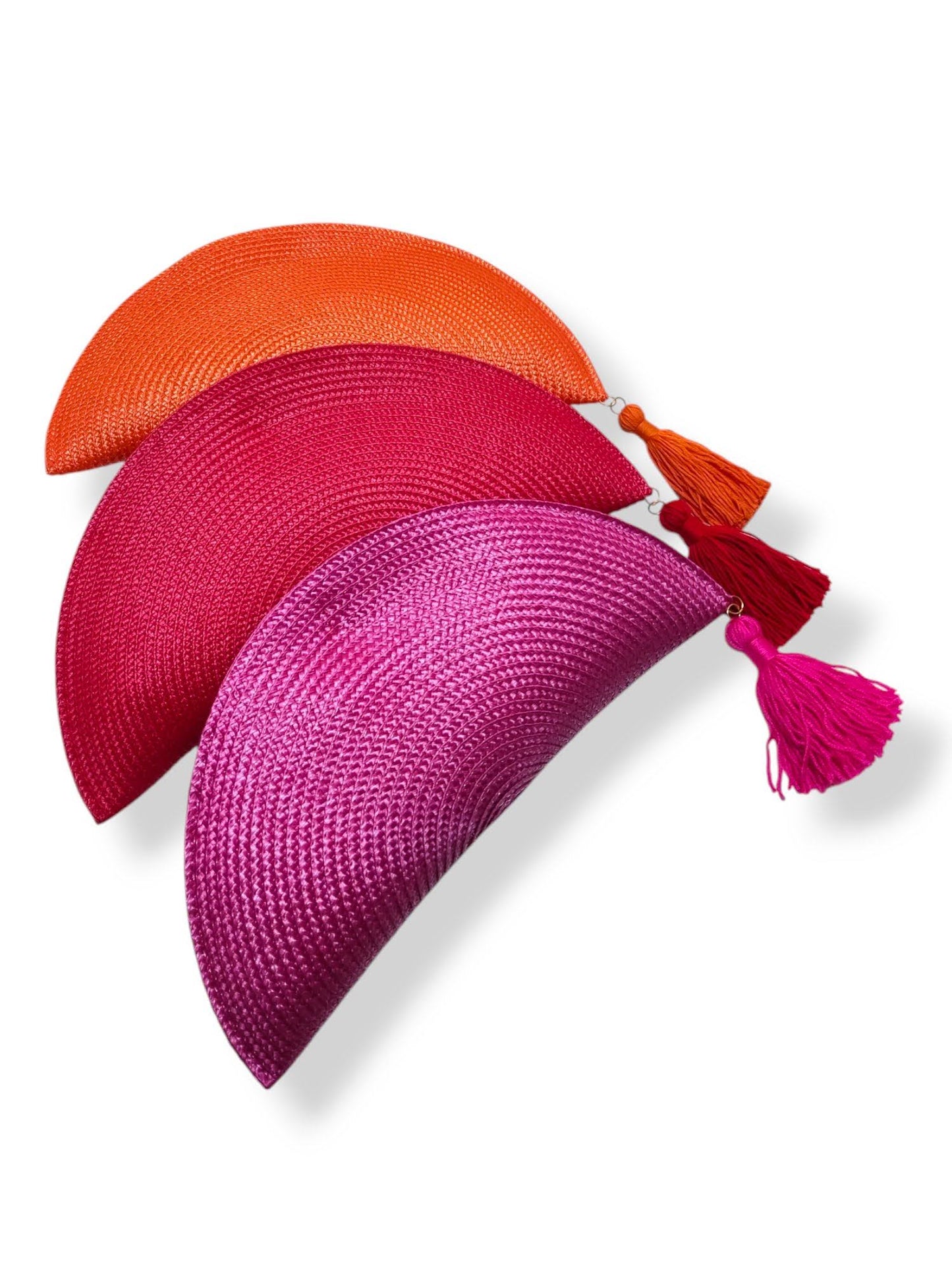Composición de tres bolsos clutch con forma de abanico en colores naranja, fucsia y rojo.