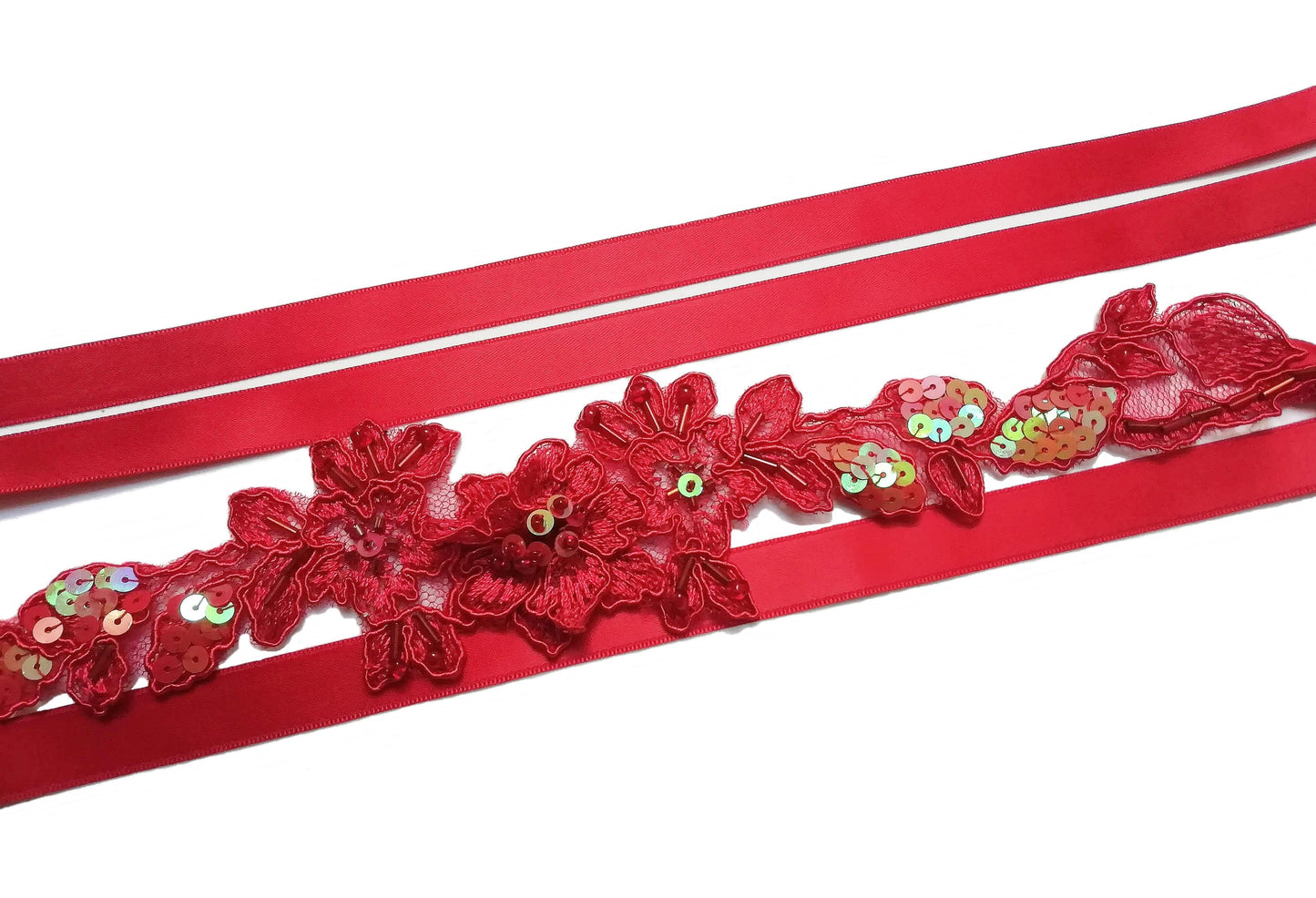 Vista del fajín rojo con cintas de raso a los lados, elegante y versátil.