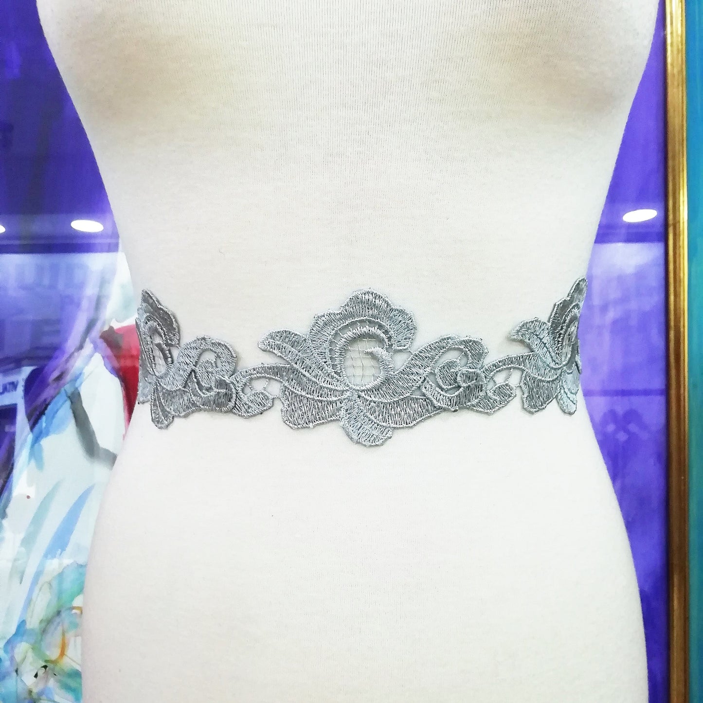 Cinturón de encaje plateado en el maniquí.