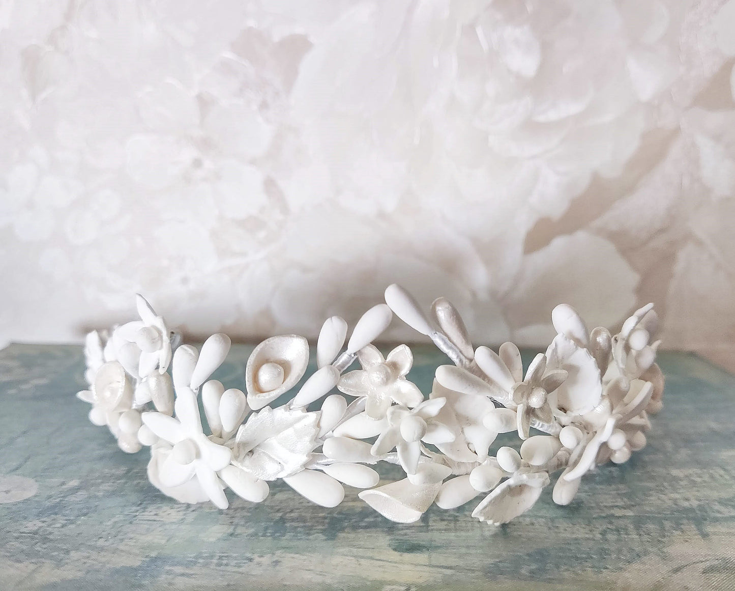 Primer plano frontal de la tiara blanca, destacando su diseño elegante y luminoso