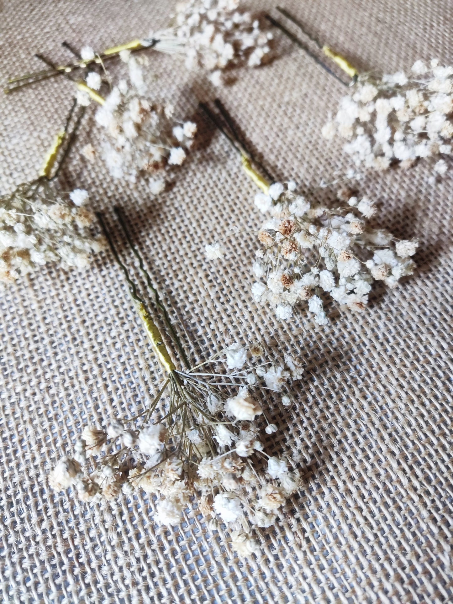 Primer plano angular de horquillas con paniculata color crudo sobre tela arpillera