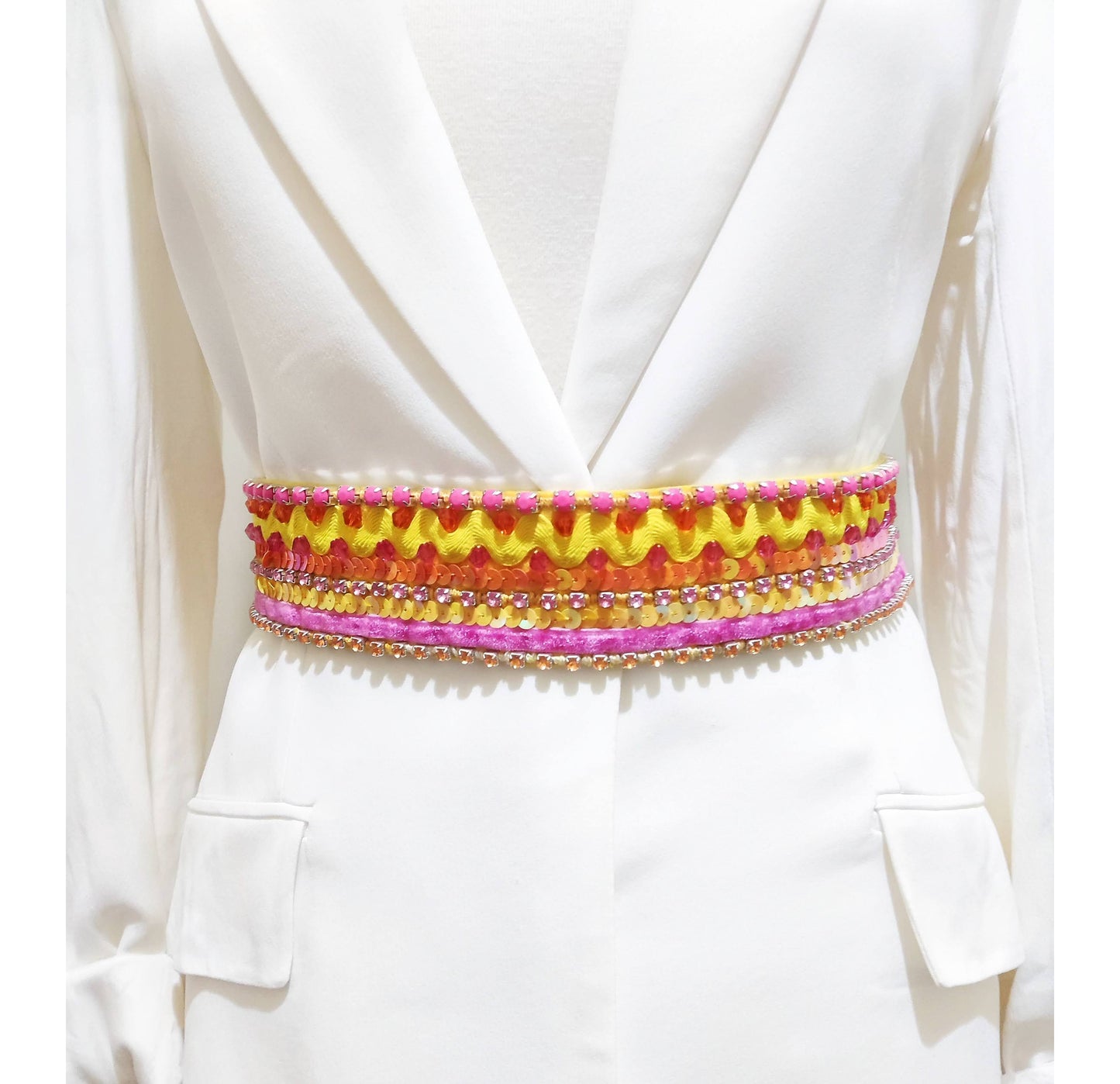 Cinturón boho chic bordado en amarillo, naranja y rosa colocado en un maniquí.
