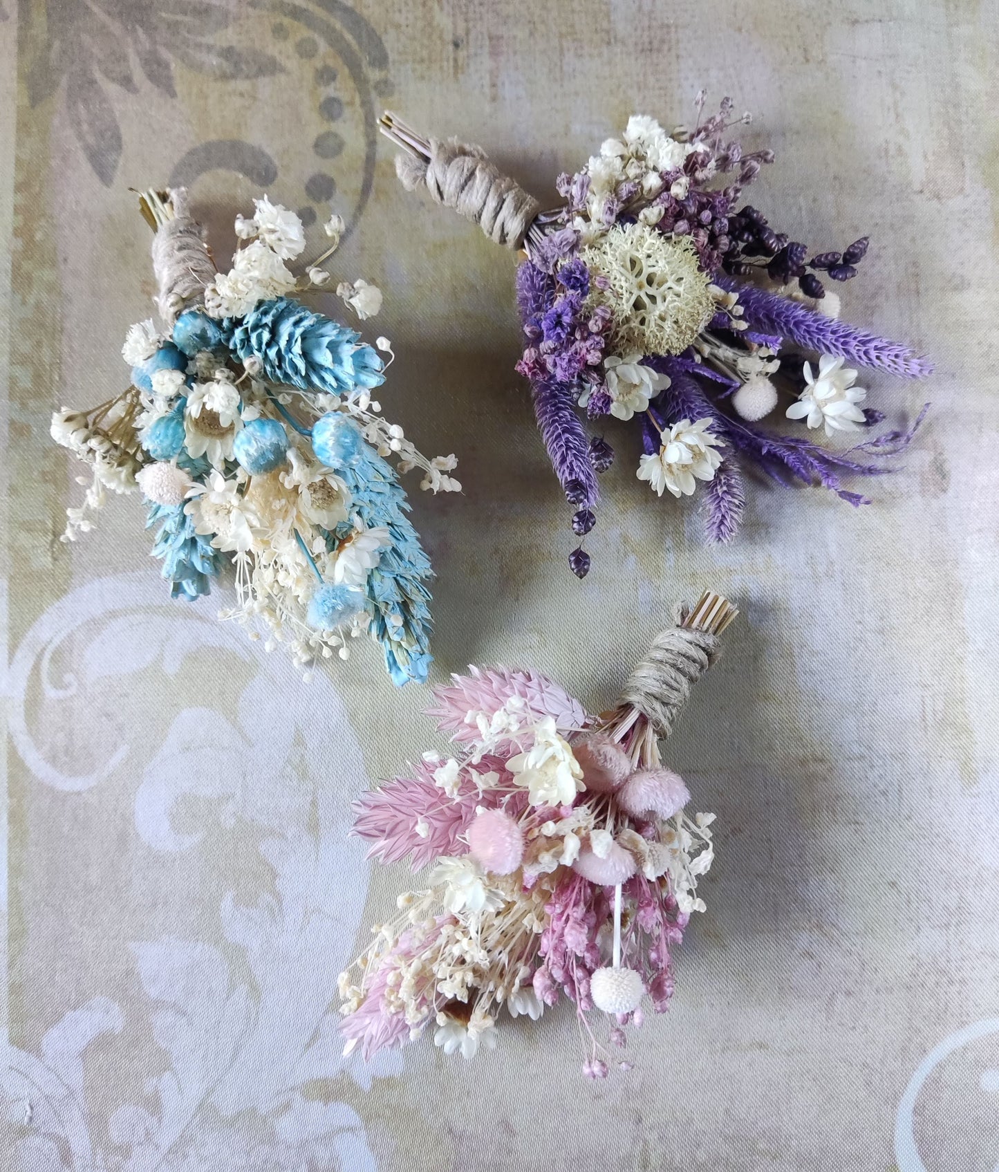 Tres ramilletes de solapa en diferentes colores con flores preservadas.