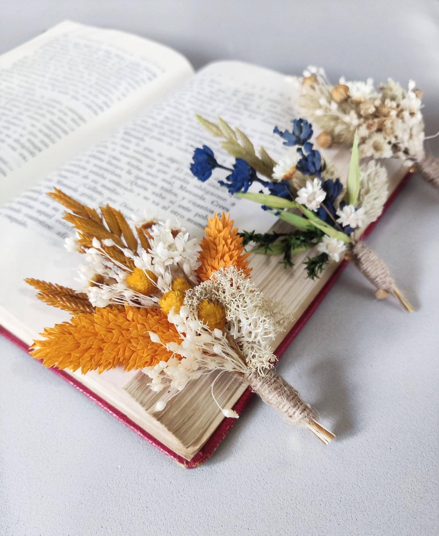 Prendido de boda sobre un libro abierto junto a otros modelos de diferentes colores