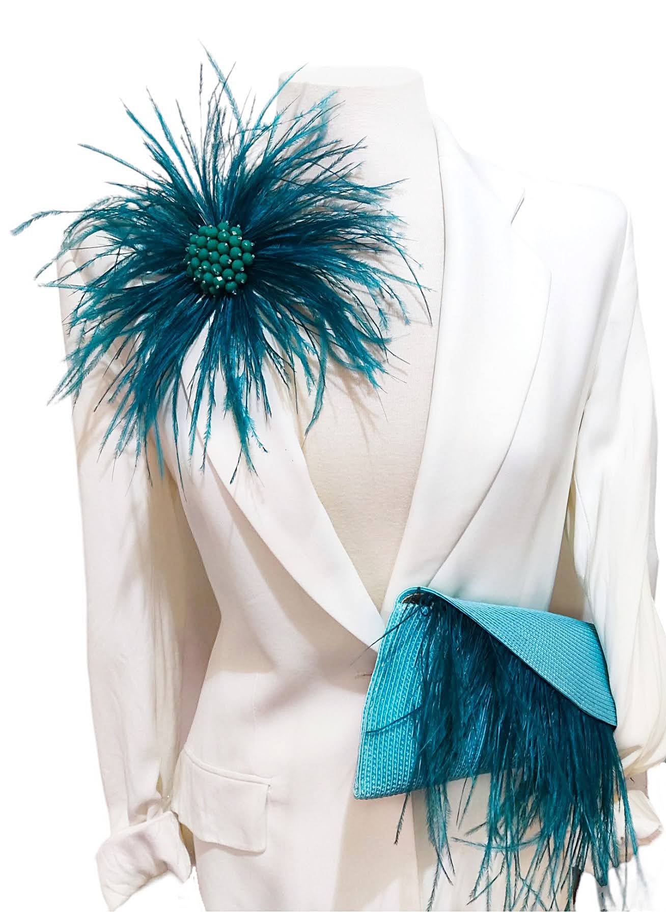 Broche floral de plumas color teal con clutch coordinado, perfecto para looks de boda sofisticados.