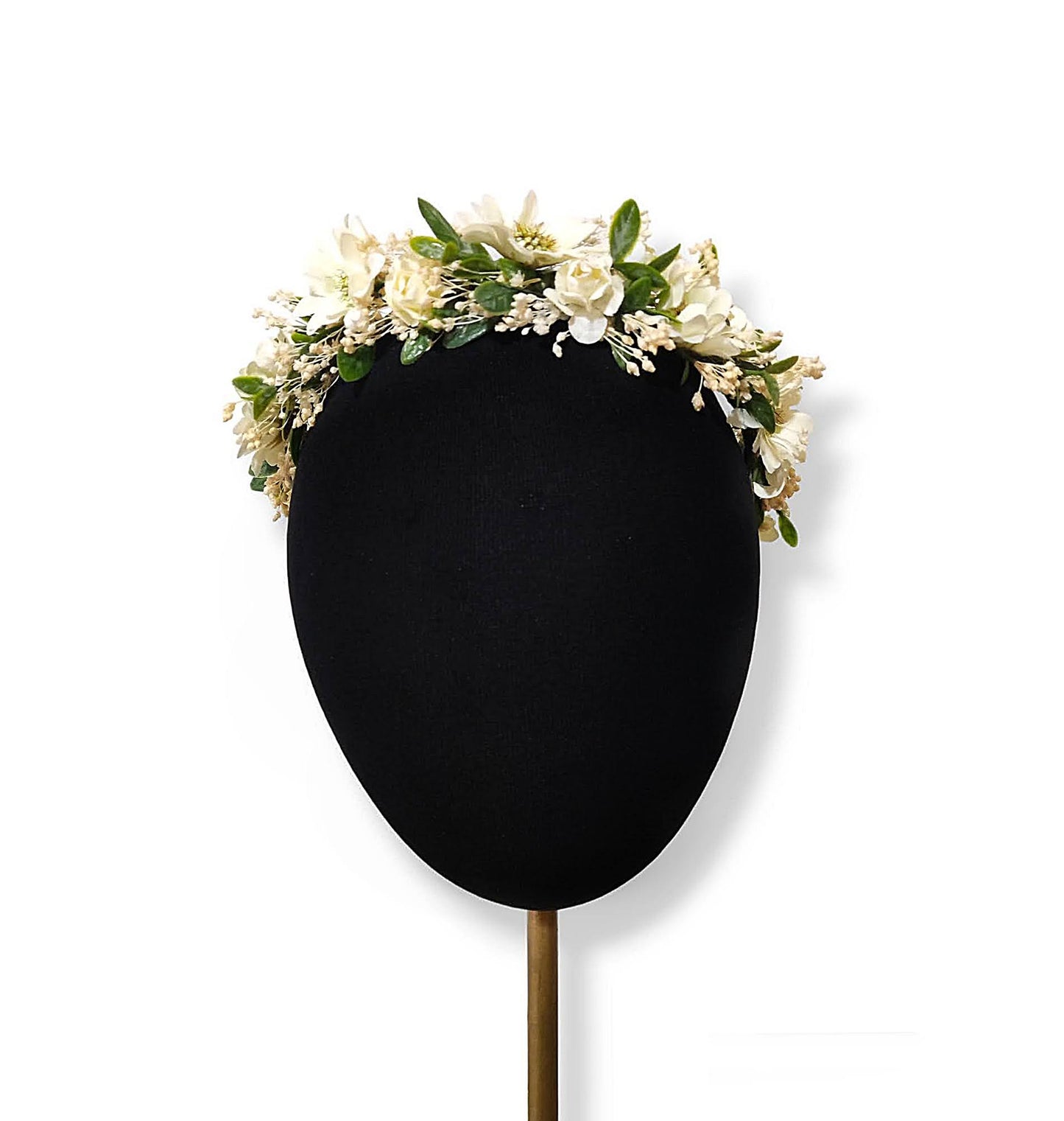 Vista frontal de la corona floral beige y verde colocada en la cabeza de un maniquí.