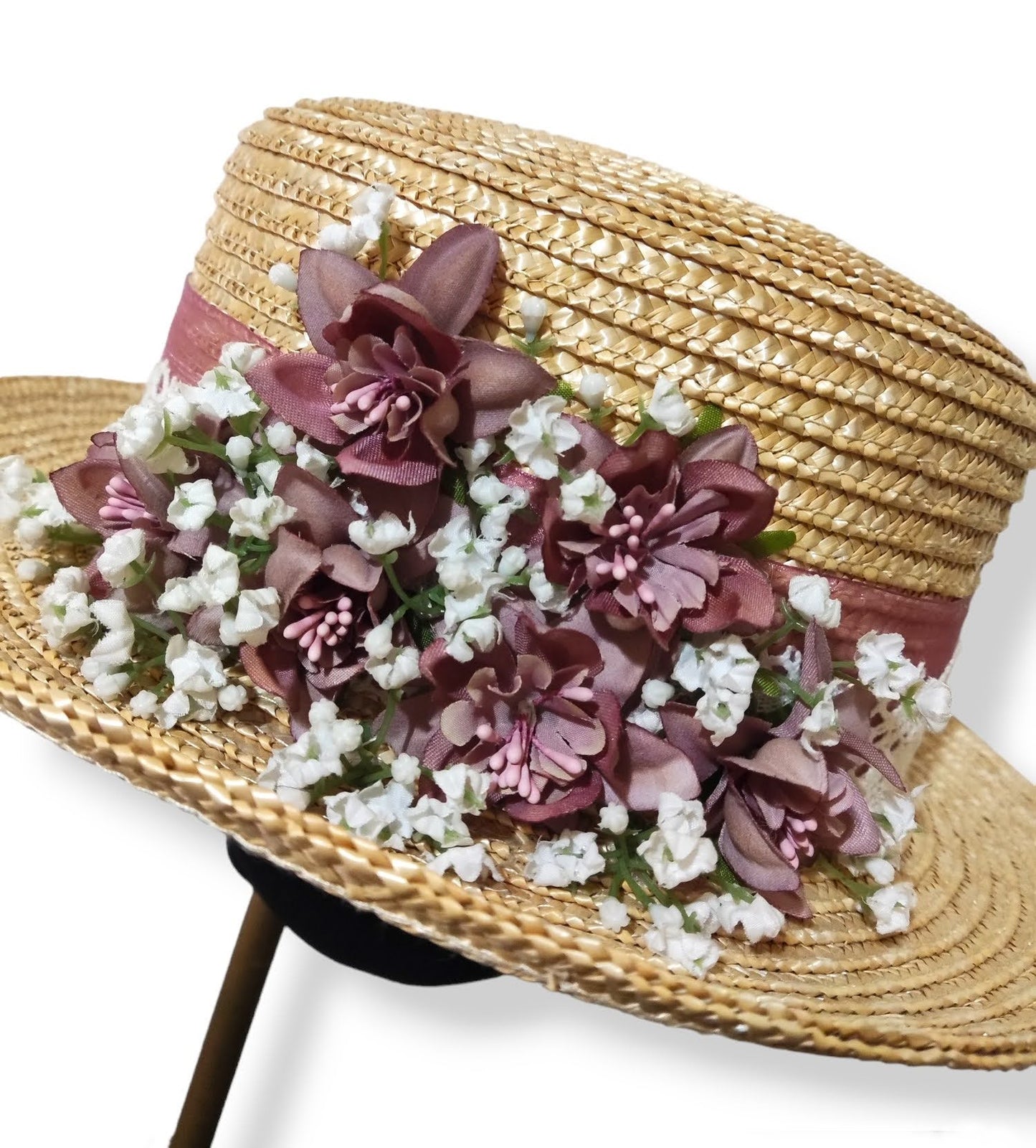 Primer plano del bouquet de flores en rosa viejo y blanco sobre chistera de paja natural.