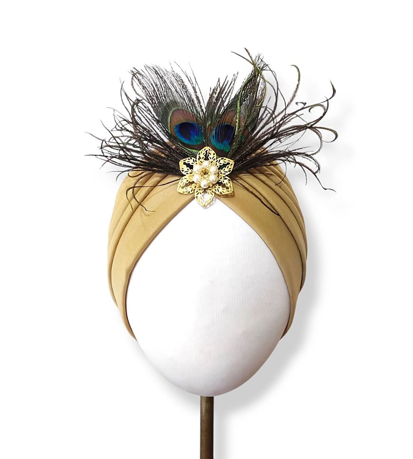 Turbante color tostado con plumas y broche de perlas.