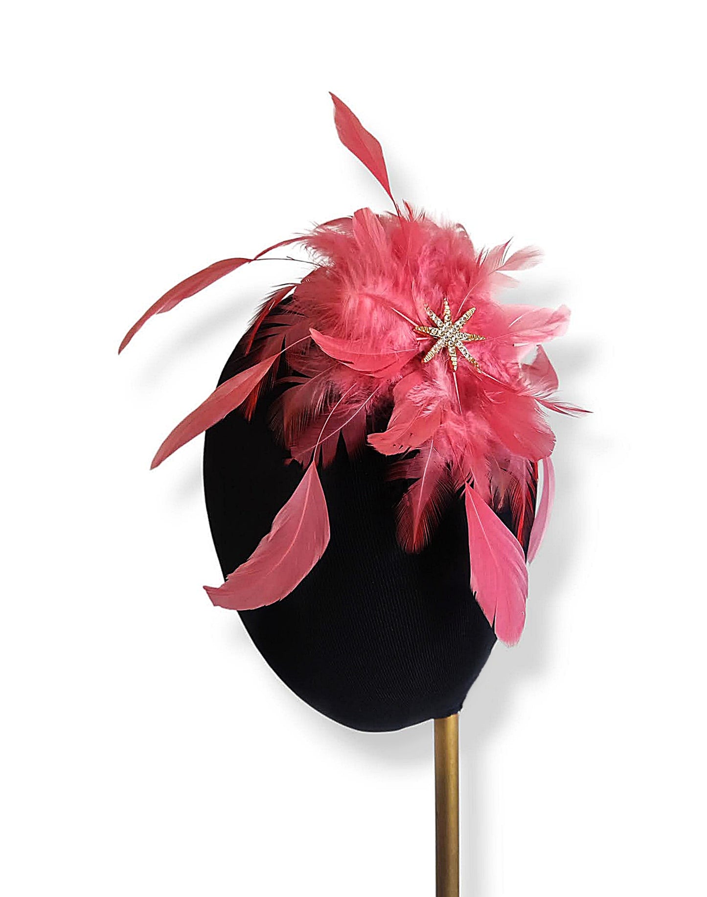 Primer plano del tocado de plumas coral de medio perfil colocado en una cabeza de maniquí.