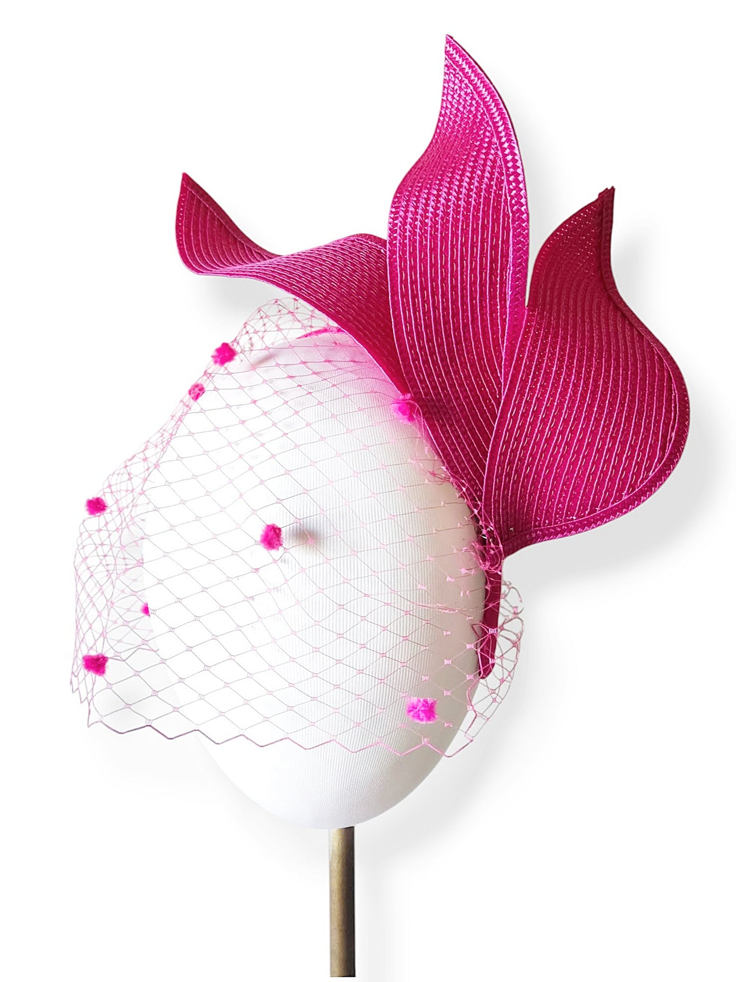 Detalle de las hojas que adornan el tocado fucsia
para invitadas a bodas y eventos.