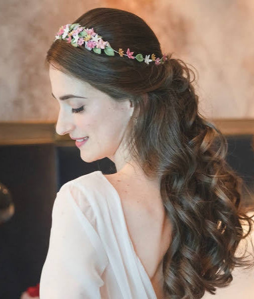 Novia con la corona floral en tonos rosa, blanco y dorado.