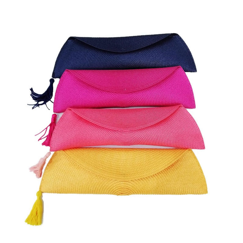 Cuatro bolsos clutch en azul marino, fucsia, amarillo y coral, ideales para cualquier ocasión.
