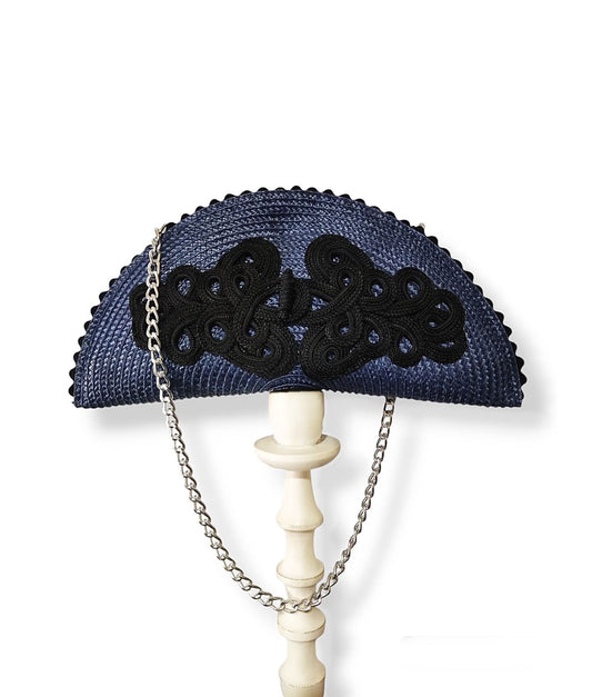 Bolso de paja azul marino en forma de abanico con alamar negro y cadena.