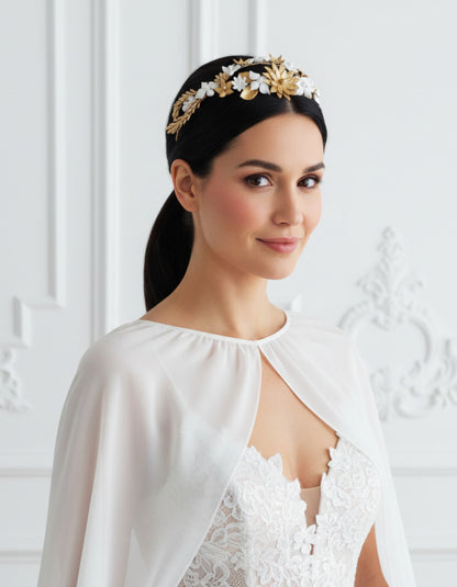 Braut trägt eine Tiara mit weißen und goldenen Porzellanblumen, mittig auf dem Kopf positioniert, kombiniert mit einem glatten, tiefen Pferdeschwanz. Handgefertigtes Design von Glo&Sons.