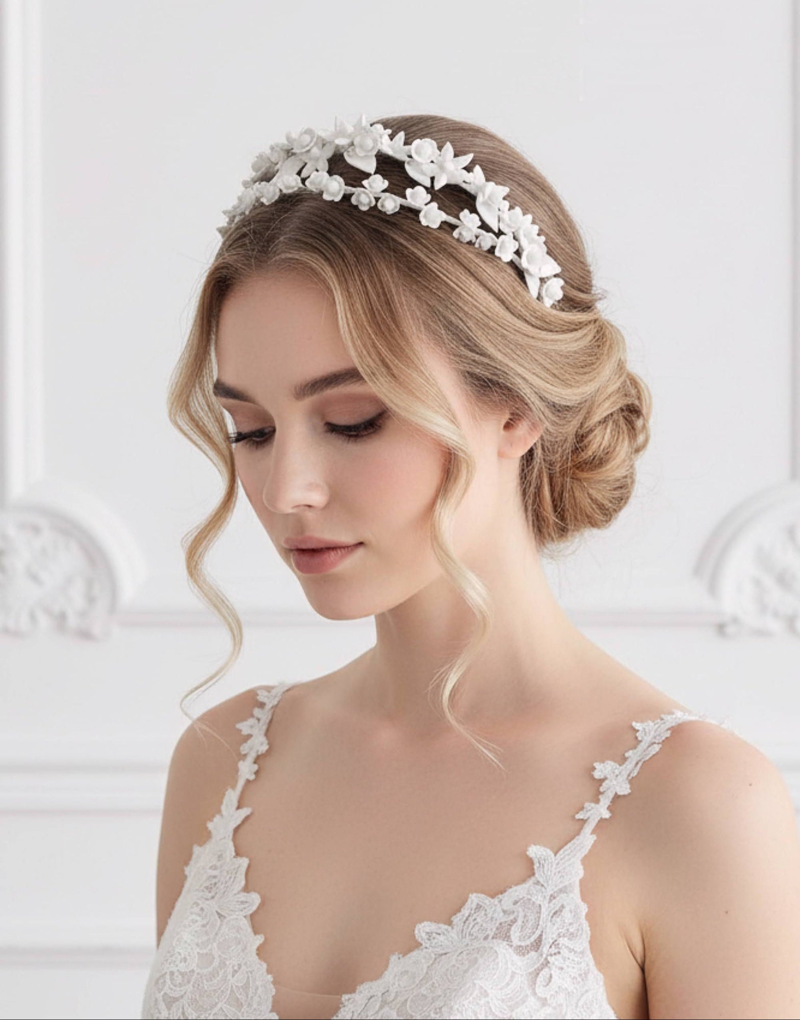 Diadema doble de novia con flores de porcelana blanca, estilo romántico, colocada sobre recogido bajo con ondas suaves
