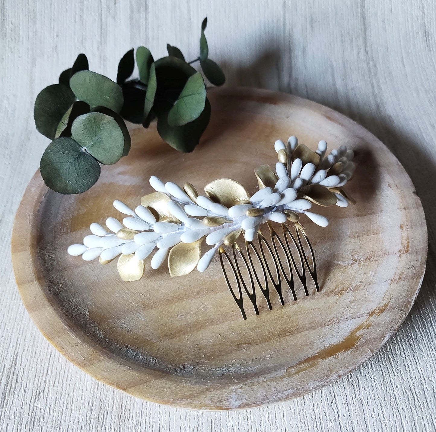 Pettine da sposa decorativo con pistilli e foglie in porcellana bianca e dorata, montato su base dorata. Accessorio artigianale ideale per completare l’acconciatura da matrimonio. Glo&Sons