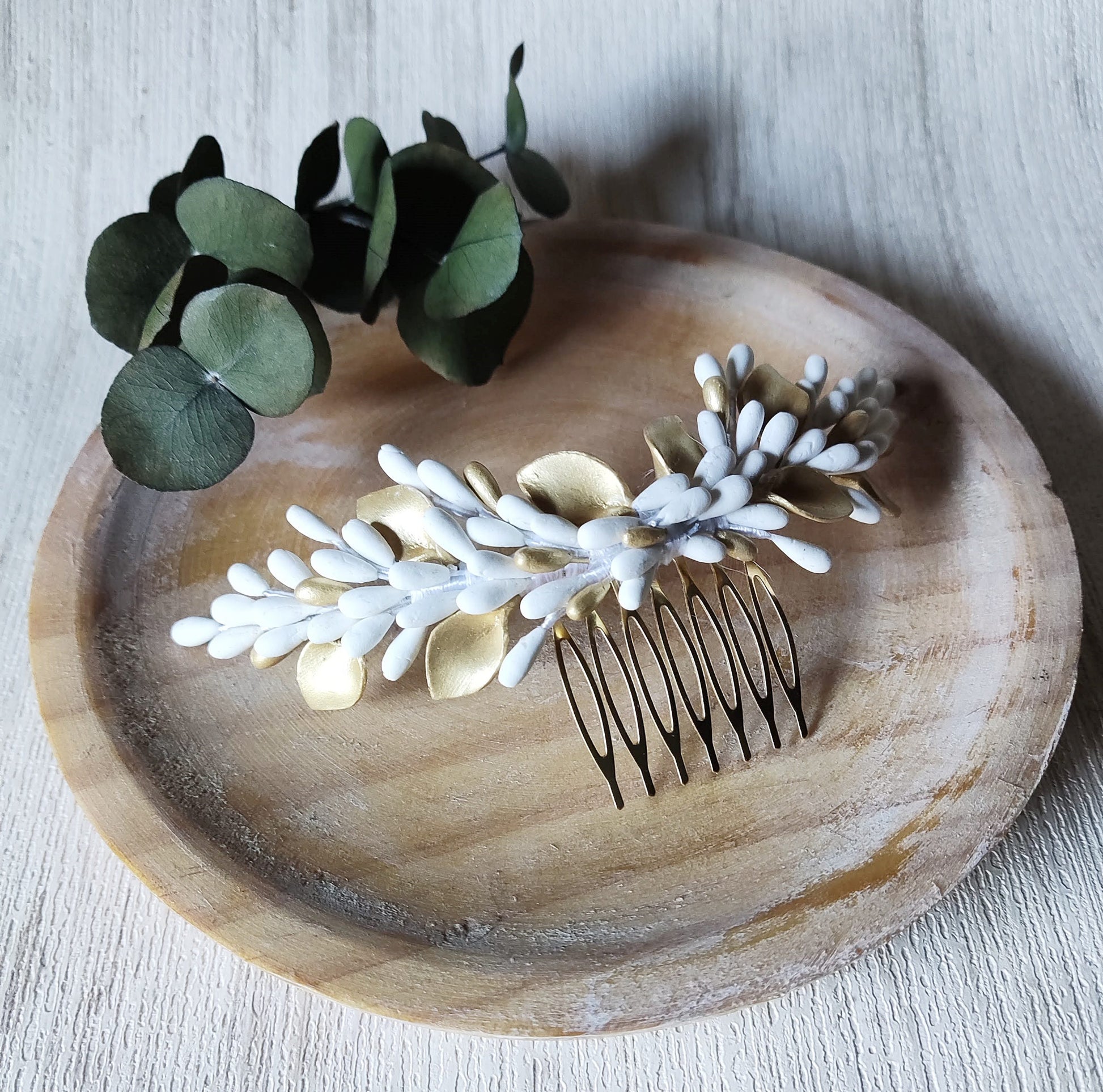 Pettine da sposa decorativo con pistilli e foglie in porcellana bianca e dorata, montato su base dorata. Accessorio artigianale ideale per completare l’acconciatura da matrimonio. Glo&Sons