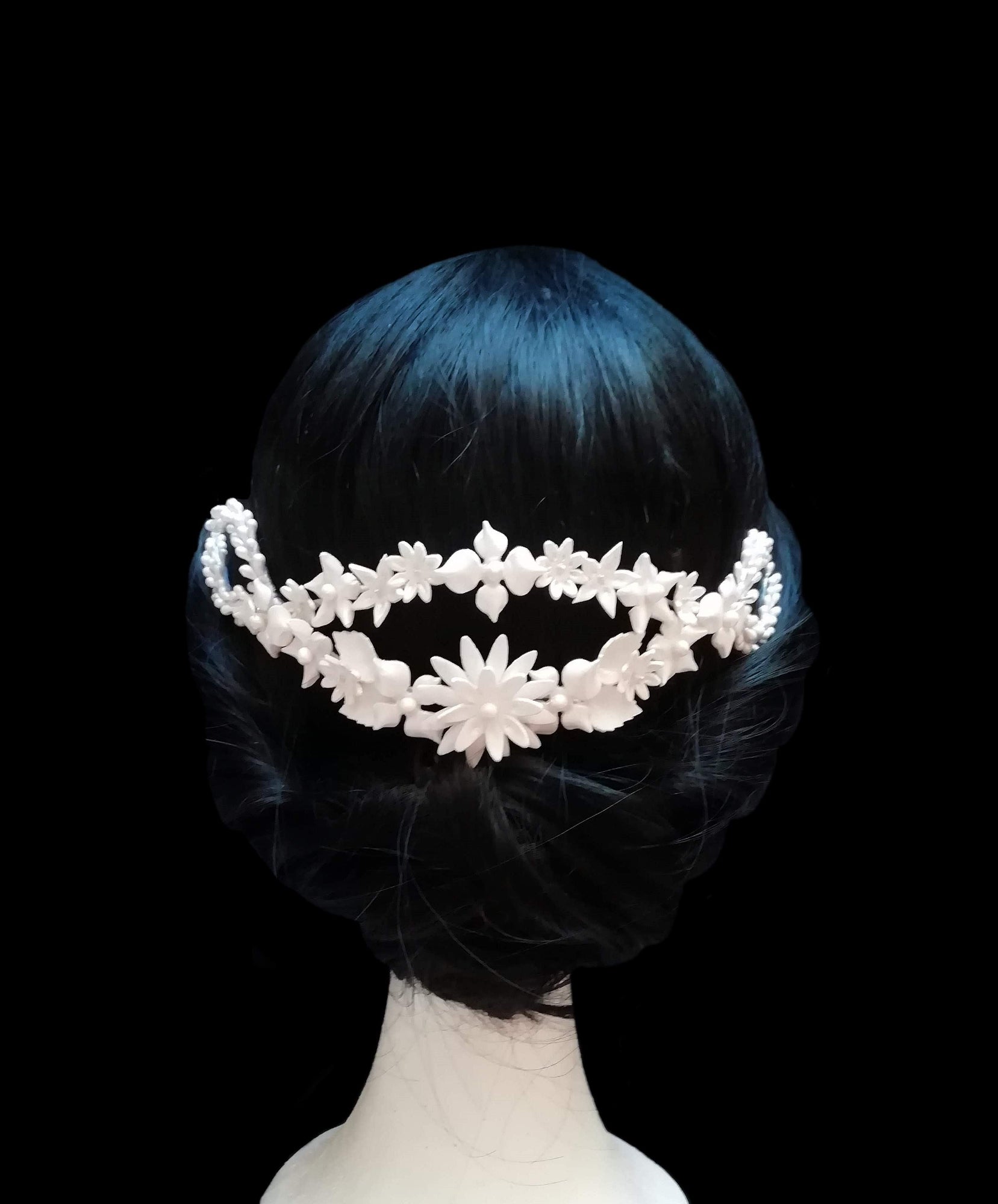 Tiara posteriore da sposa in porcellana bianca, decorata con fiori e foglie delicate, indossata con uno chignon elegante. Design artigianale realizzato a mano da Glo&Sons